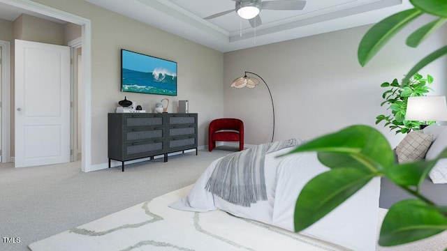 carpeted bedroom featuring ceiling fan and a tray ceiling