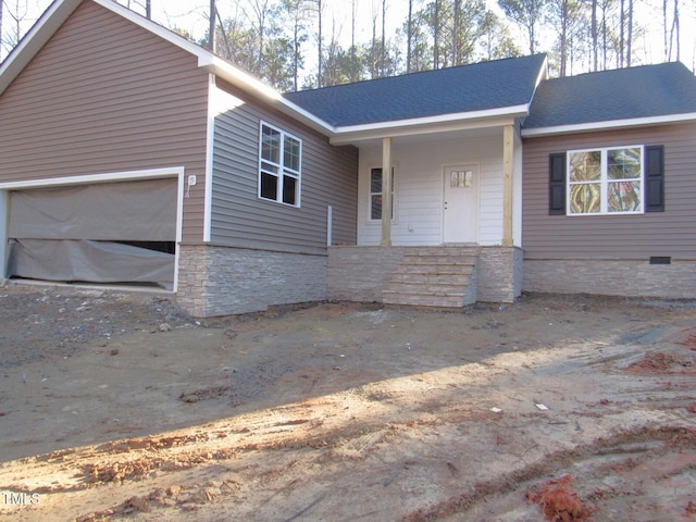 single story home featuring covered porch, stone siding, and an attached garage