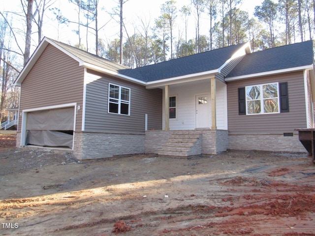 ranch-style home with a garage, stone siding, and roof with shingles