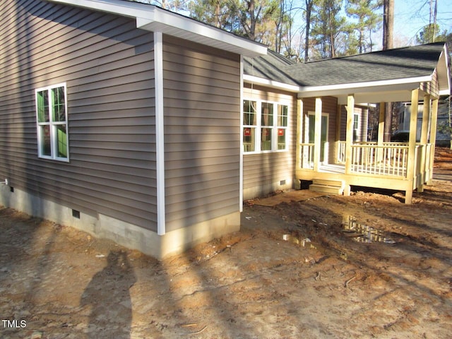 view of side of property with roof with shingles, a porch, and crawl space