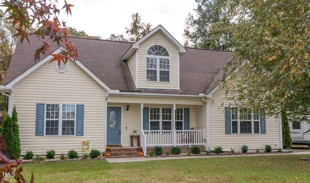 new england style home with a porch and a front yard