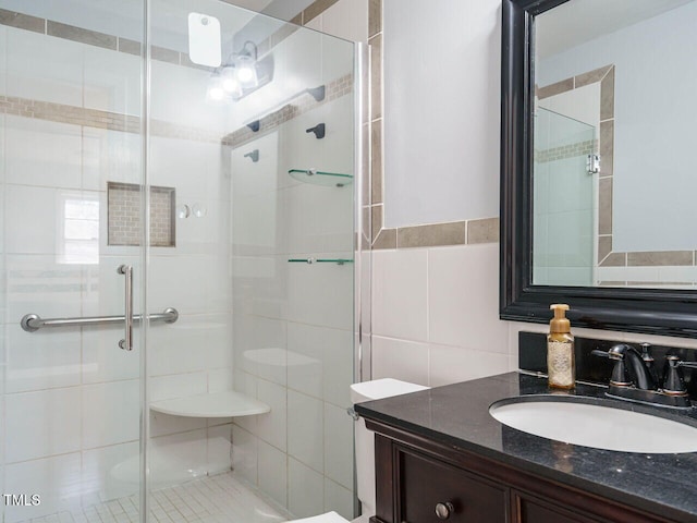 bathroom with an enclosed shower, vanity, tile walls, and tasteful backsplash