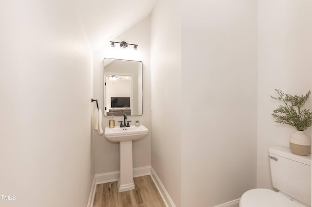 bathroom featuring hardwood / wood-style floors, toilet, and vaulted ceiling