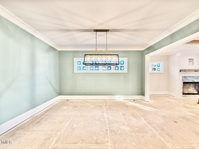 unfurnished dining area featuring ornamental molding and a fireplace