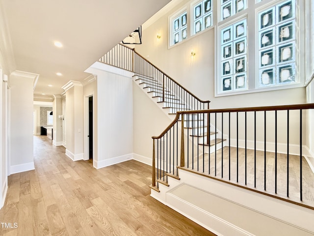 stairway featuring ornamental molding, recessed lighting, baseboards, and wood finished floors