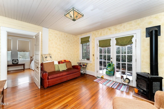 living room featuring hardwood / wood-style flooring, a wood stove, and french doors