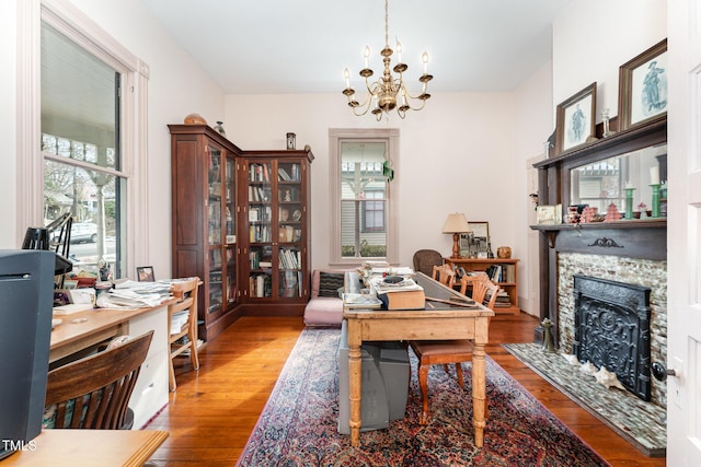 office space with a fireplace, light hardwood / wood-style flooring, and a chandelier