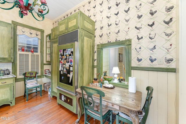 dining area with ornamental molding and light hardwood / wood-style floors