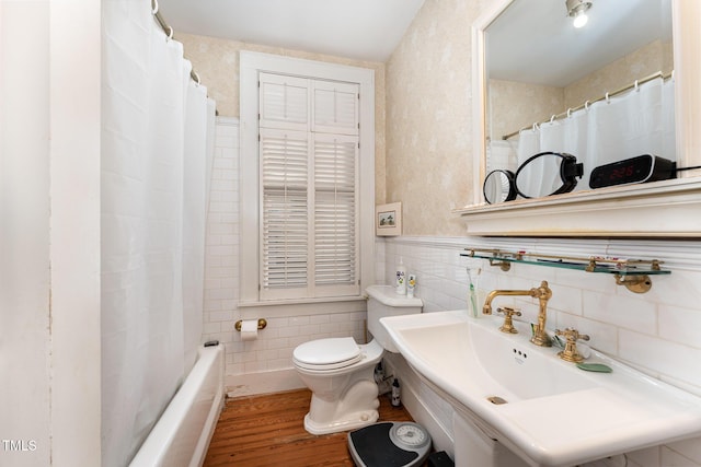 bathroom featuring tile walls, hardwood / wood-style floors, sink, and toilet