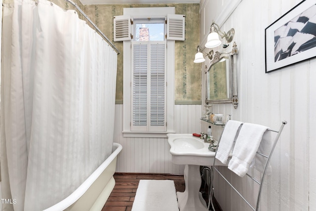 bathroom with hardwood / wood-style flooring and shower / tub combo