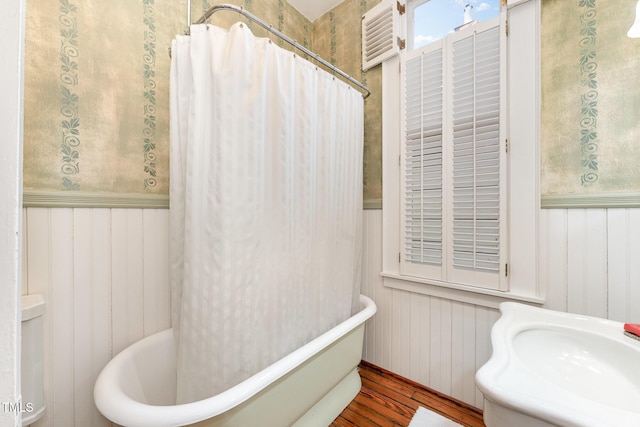 bathroom featuring hardwood / wood-style flooring and shower / tub combo with curtain