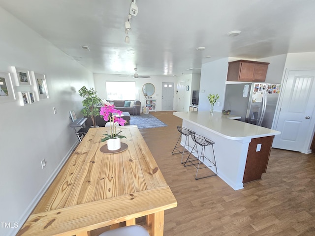 kitchen featuring ceiling fan, hardwood / wood-style floors, and stainless steel fridge with ice dispenser