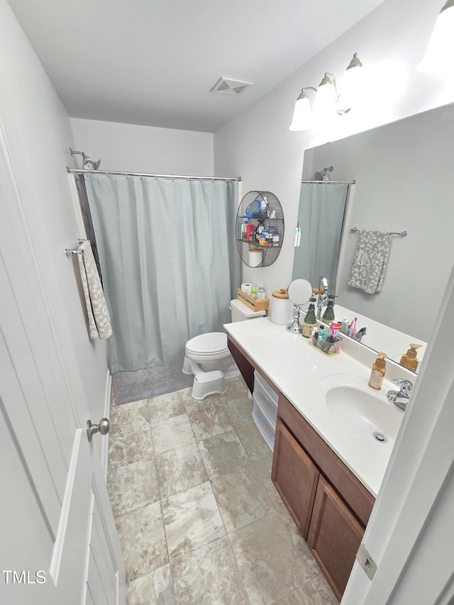 bathroom with toilet, vanity, and a shower with shower curtain