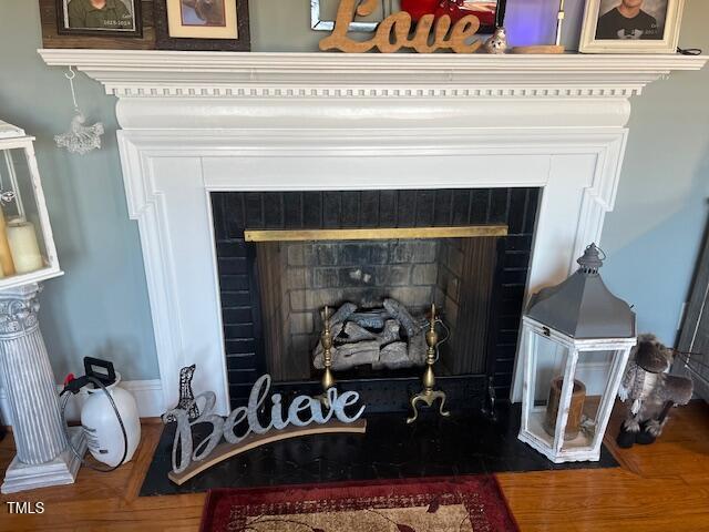 details featuring hardwood / wood-style floors and a tile fireplace