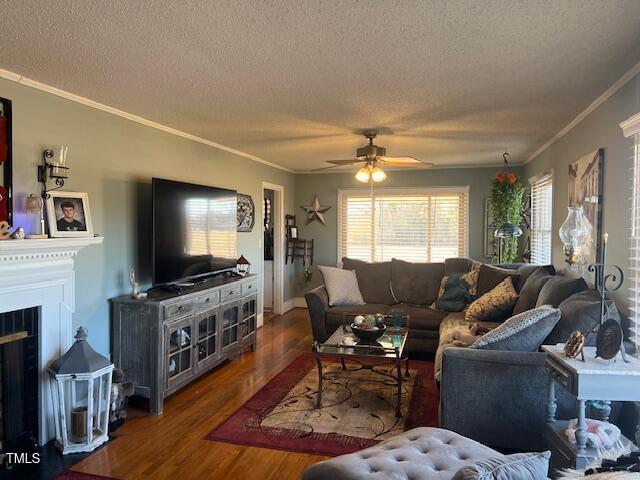 living room featuring a textured ceiling, ceiling fan, crown molding, and wood-type flooring