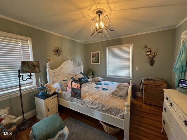 bedroom featuring an inviting chandelier, dark hardwood / wood-style flooring, and crown molding