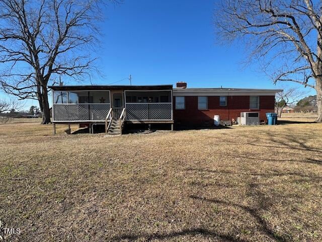 back of house with a yard and a sunroom