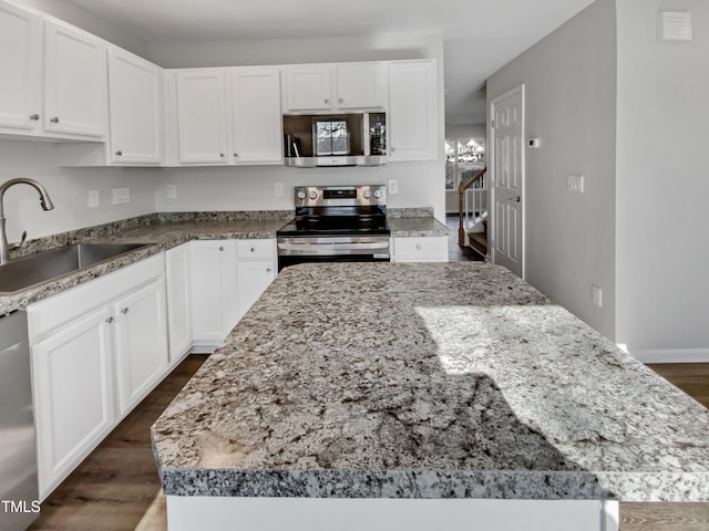 kitchen with sink, white cabinets, a center island, and appliances with stainless steel finishes