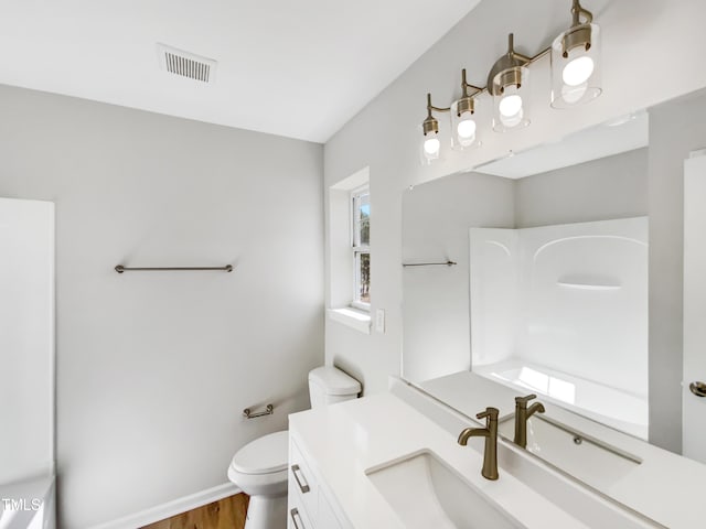 bathroom featuring vanity, toilet, and hardwood / wood-style floors