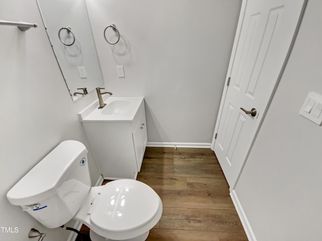 bathroom featuring wood-type flooring, toilet, and vanity