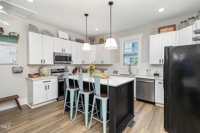 kitchen with stainless steel appliances, white cabinets, and a kitchen island