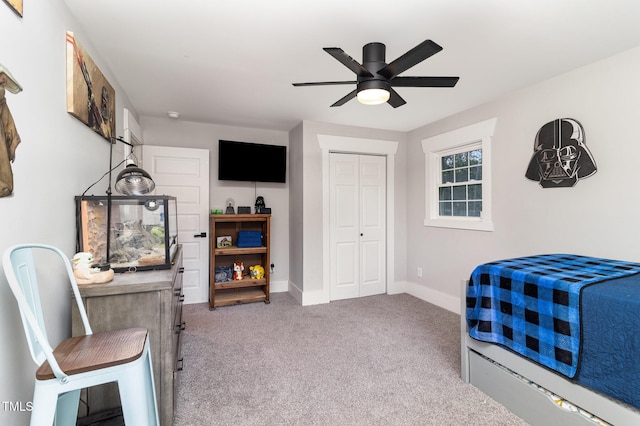 carpeted bedroom featuring ceiling fan and a closet