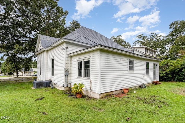 view of property exterior with central air condition unit and a lawn