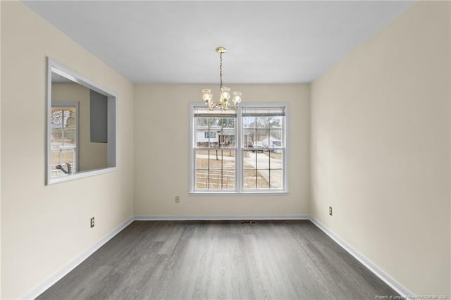 unfurnished dining area featuring an inviting chandelier and dark hardwood / wood-style floors