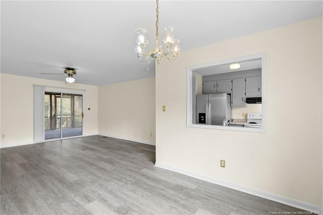 unfurnished living room with hardwood / wood-style flooring and ceiling fan with notable chandelier