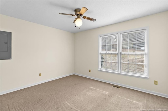 empty room featuring ceiling fan, electric panel, and light carpet