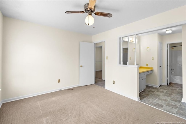 unfurnished bedroom with ceiling fan, connected bathroom, and light carpet