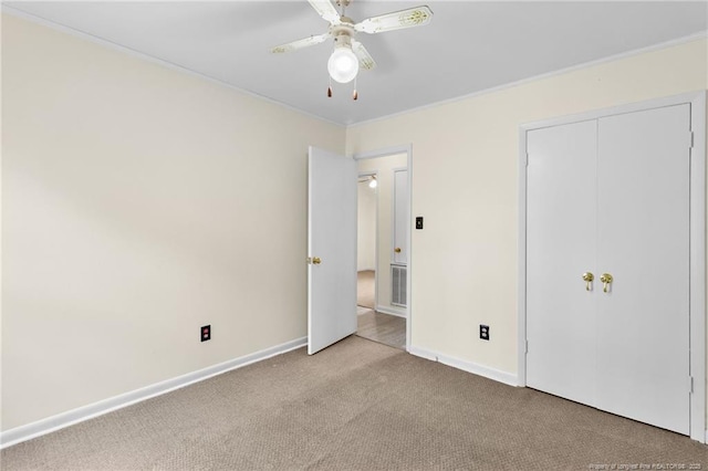 unfurnished bedroom featuring ceiling fan, light colored carpet, and a closet