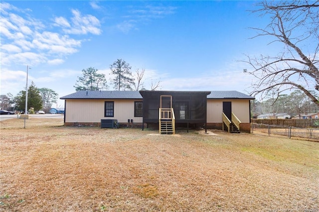 back of house with a sunroom and a yard