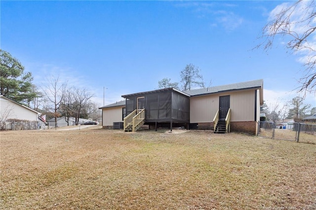 rear view of house featuring a sunroom, a yard, and central AC unit