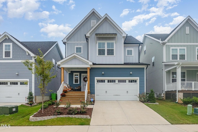 craftsman inspired home with a garage, a front yard, and a porch