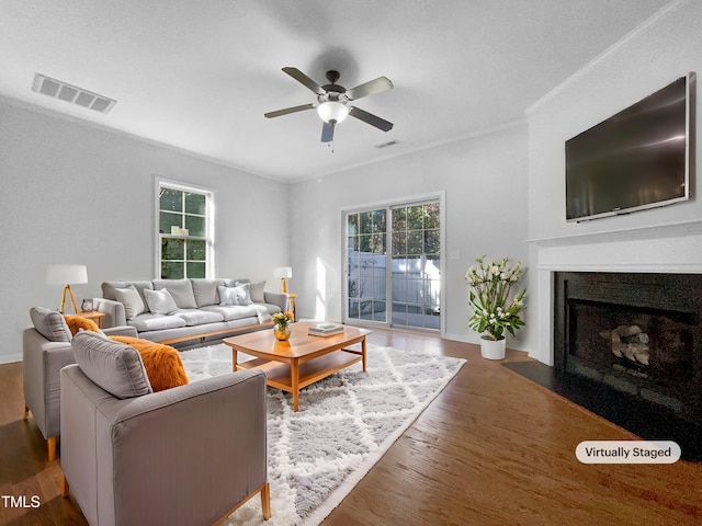 living room featuring ceiling fan, dark wood-type flooring, and ornamental molding