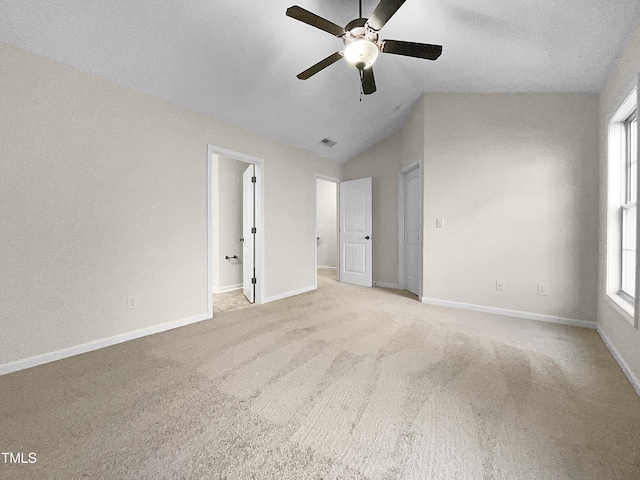 unfurnished bedroom featuring ceiling fan, light colored carpet, and vaulted ceiling