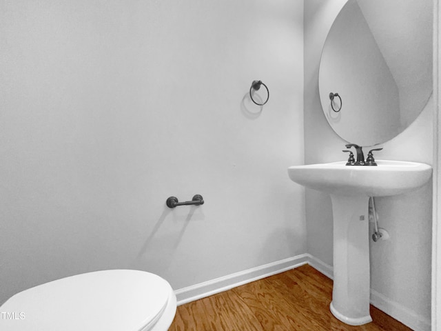 bathroom featuring hardwood / wood-style flooring and toilet