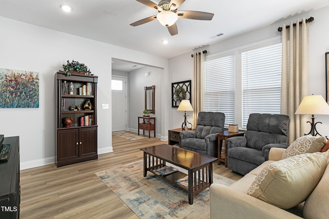 living room with ceiling fan, a wealth of natural light, and light hardwood / wood-style floors