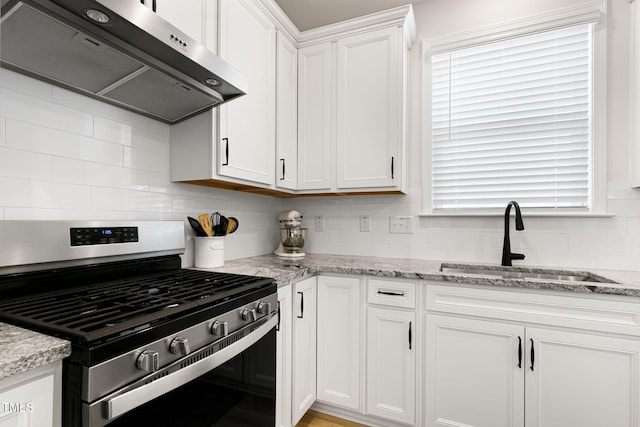 kitchen with ventilation hood, sink, white cabinets, light stone countertops, and stainless steel gas range