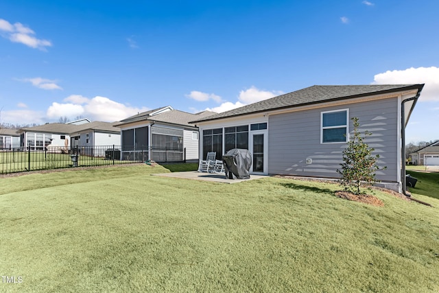 rear view of house with a patio, a sunroom, and a lawn