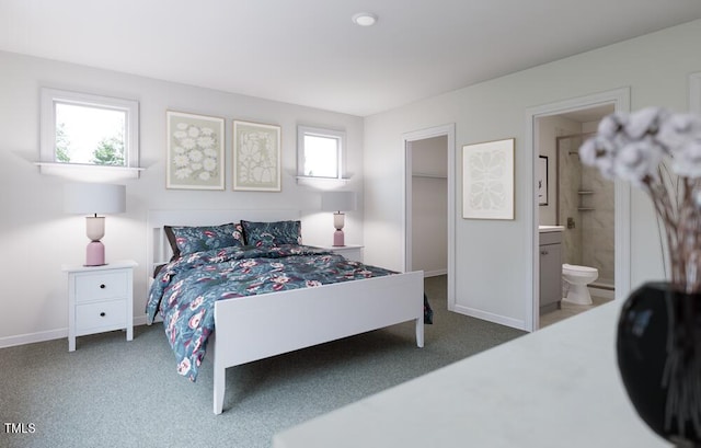 bedroom featuring ensuite bathroom, carpet floors, and multiple windows