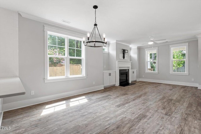 2905 Cammie St, Durham, NC 27705 - unfurnished living room with ornamental molding, wood finished floors, a ceiling fan, a chandelier, and a glass covered fireplace