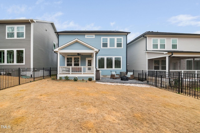 rear view of property featuring covered porch, a lawn, and ceiling fan