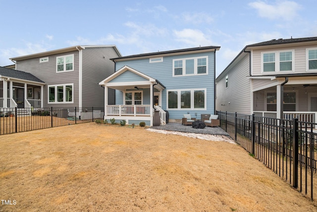 back of house with covered porch, a patio area, ceiling fan, a yard, and an outdoor living space