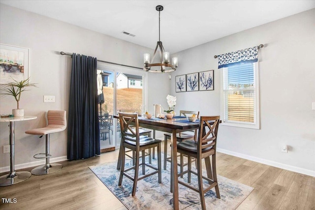 dining area featuring light hardwood / wood-style floors and a notable chandelier