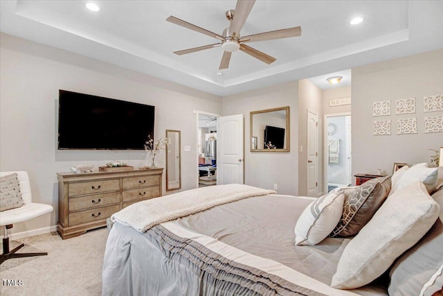 bedroom with light carpet, ceiling fan, connected bathroom, and a raised ceiling