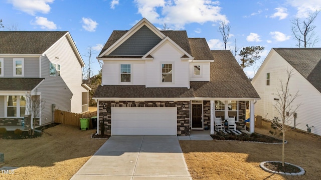 view of front of property with a porch, a garage, and a front lawn