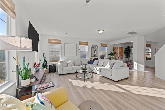 living room with a healthy amount of sunlight and light hardwood / wood-style flooring