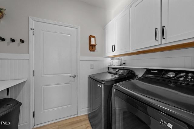 laundry area featuring independent washer and dryer, cabinets, and light wood-type flooring